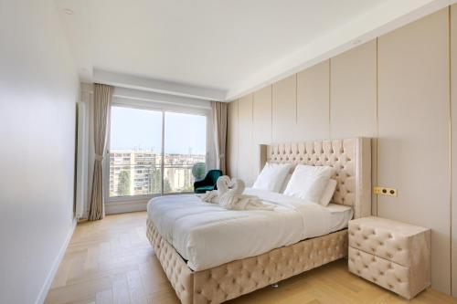 une chambre avec un grand lit avec un animal en peluche dessus dans l'établissement 101 Penthouse Royal à Paris avec Vue Imprenable sur la Tour Eiffel, à Paris