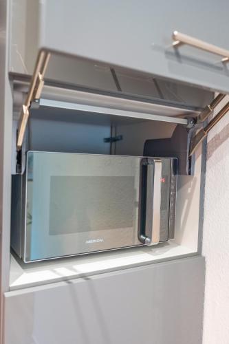 a microwave on a shelf in a refrigerator at Stylisch - ruhig - gemütlich - zentral - einladend in Krefeld