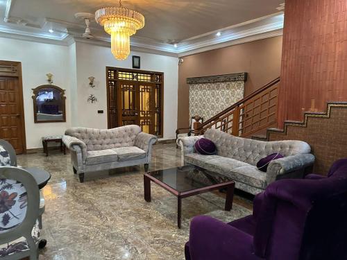 a living room with two couches and a table at The Red Tree Family Guest House in Karachi