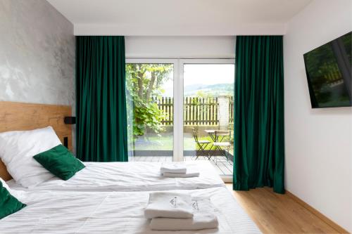 a bedroom with a large bed with green curtains at Villa Gorczański Zakątek Agroturystyka in Konina
