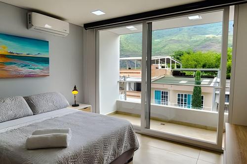 een slaapkamer met een bed en een groot raam bij 301 Norte cali - The view in Cali