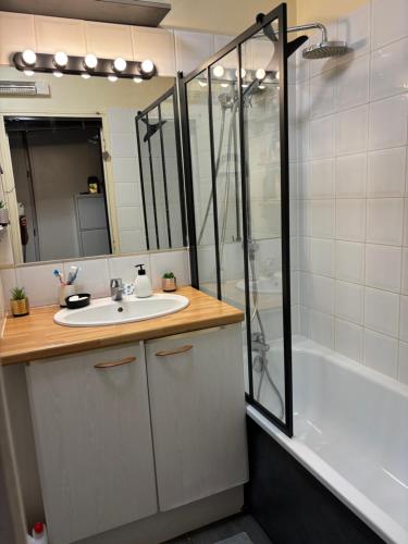 une salle de bain avec un lavabo, une douche et une baignoire dans l'établissement T2 avec piscine et terrasse dans résidence arborée, à La Rochelle