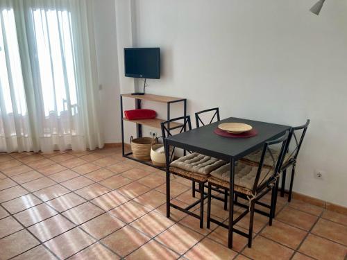 a dining room with a table and chairs and a television at EL PATIO De Arguineguìn in Arguineguín