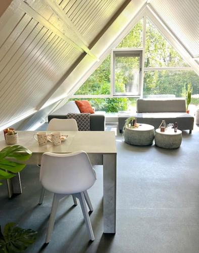 a living room with a white table and chairs at Overnacht met uniek uitzicht op tuin in Boelenslaan