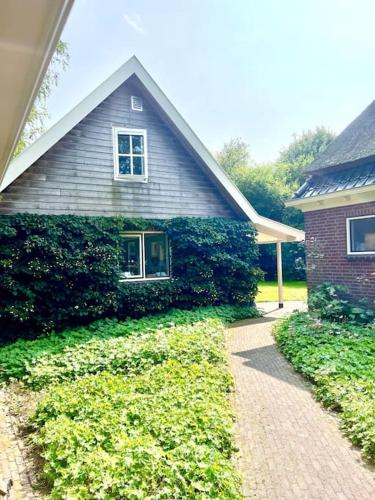 a house with ivy growing on the side of it at Overnacht met uniek uitzicht op tuin in Boelenslaan