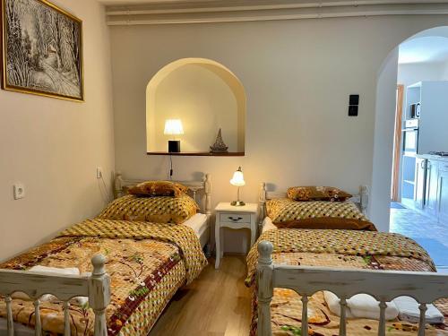 a bedroom with two beds and a mirror at Júlia Apartmanház Harkány in Harkány