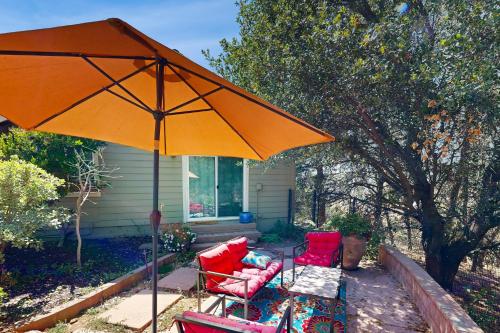 a patio with two chairs and an orange umbrella at The Great Escape in Copperopolis