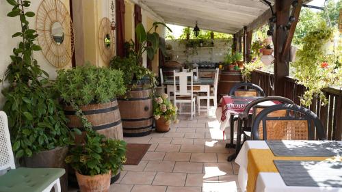 a patio with tables and chairs and potted plants at La Fontenelle Chambres d'Hôtes in Sainte-Sévère