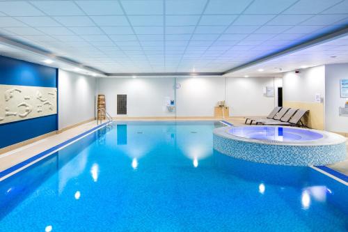 a large swimming pool with a large blue swimming pool at Nottingham Belfry Hotel & Spa in Nottingham