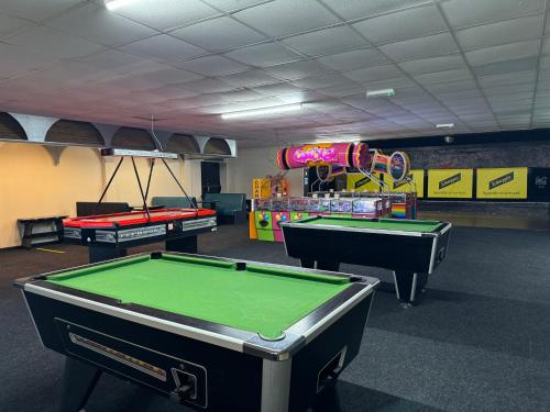 a room with three pool tables and a arcade at 62 M&T Chalets , 2 bed detached chalet Florida holiday park Hemsby in Hemsby