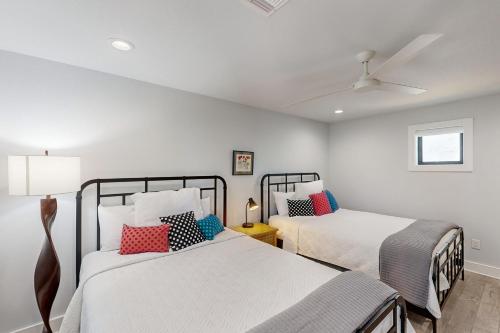 two beds in a room with white walls at Sailboat Cove in Canyon Lake