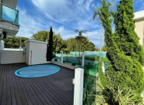 a house with a deck with a blue trampoline at AP completo na Praia de Palmas, SC in Governador Celso Ramos