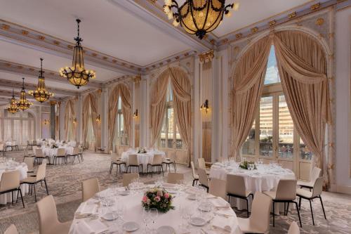 a banquet hall with white tables and chairs and chandeliers at Hotel Maria Cristina, a Luxury Collection Hotel, San Sebastian in Donostia-San Sebastián