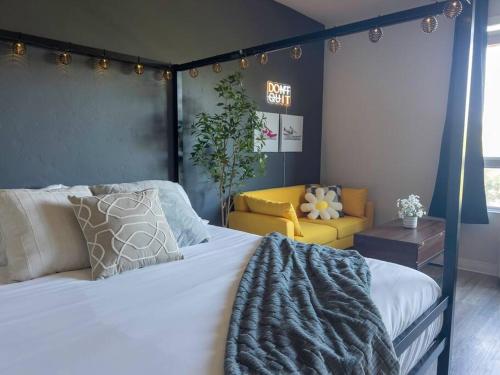 ボイジーにあるIconic Nike Studio & Romantic Canopy Glowのベッドルーム(大型ベッド1台、黄色いソファ付)