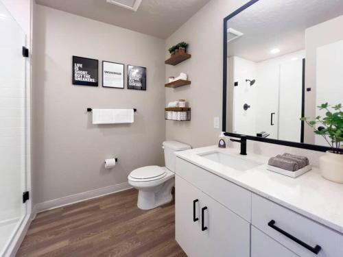 ボイジーにあるIconic Nike Studio & Romantic Canopy Glowのトイレと鏡のある白いバスルーム