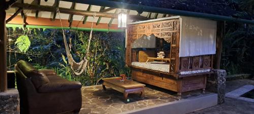 a room with a bed and a couch and a table at Mi Casa - The gem of Ijen in Banyuwangi