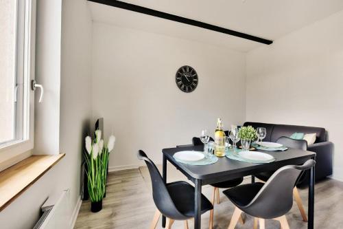 a dining room with a black table and chairs at New!!Alimentec2 in Bourg-en-Bresse