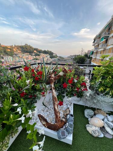 a planter with a plant on a balcony with flowers at Appartamento Rapallo Sky Garden Maria Jose Liguria - Attico vista mare - Terraces - 2 bagni- 2 Camera da Letto - Box, Wi-fi, Idromassaggio Free inteiro Attico per Voi, con Ascensore in Rapallo