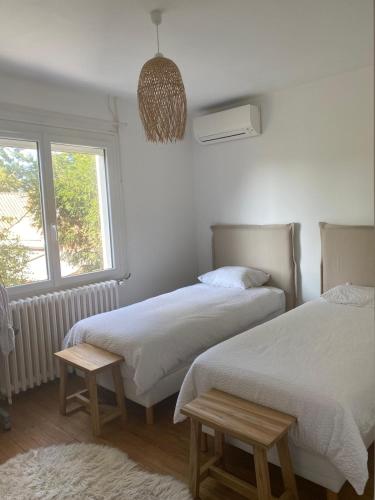 une chambre avec deux lits et une fenêtre dans l'établissement Villa-Piscine aux Abatilles 8 couchages, à Les Abatilles