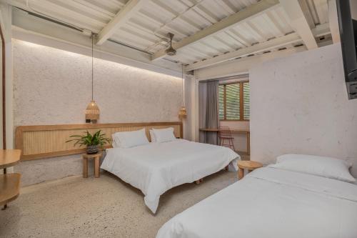 a bedroom with two beds and a table at Botánica Casa Hotel Manila by HOUSY HOST in Medellín