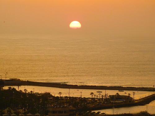 a sunset over the ocean with the sun setting at Apartamento con increíble vista al mar in Lima