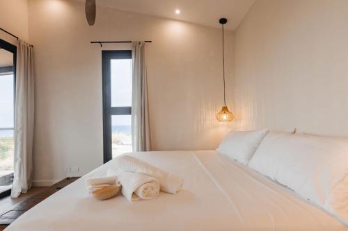 a bedroom with a large white bed with towels on it at Villa Almanglar - Tropical Home with Pool and Views in Playa Venao