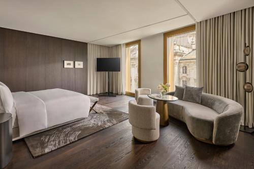 a bedroom with a bed and a couch and a table at Koenigshof, a Luxury Collection Hotel, Munich in Munich