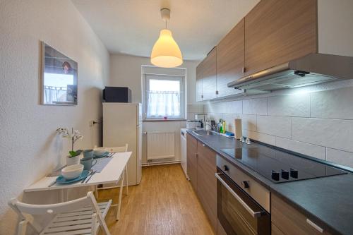 a kitchen with a counter and a table with chairs at Apartment Karli für bis zu 6 Gäste in Delitzsch