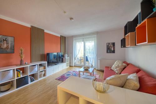 a living room with orange walls and a red couch at Apartment Karli für bis zu 6 Gäste in Delitzsch