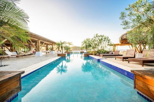 una piscina in un resort con sedie e alberi di Casa Calma Resort Home at Venao a Playa Venao