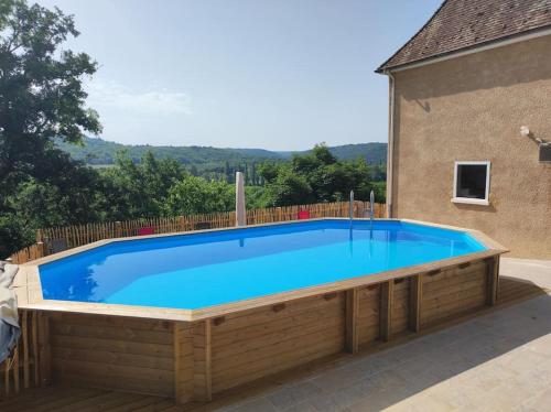une grande piscine avec une terrasse en bois dans l'établissement Maison de charme 12 pers piscine hors-sol chauffée, à Saint-Cybranet