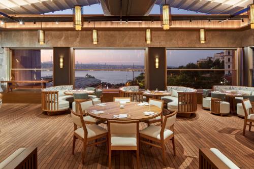 a restaurant with tables and chairs and a large window at The Ritz-Carlton, Istanbul at the Bosphorus in Istanbul