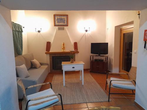 a living room with a couch and a tv at Casa dos Avós in Alcaria
