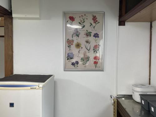 a picture of flowers on the wall in a kitchen at BLUE HOUSE - Traditional Home - 5min, Beach, Bus, Train in Beppu