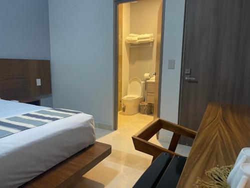 une chambre avec un lit et une salle de bain avec WC dans l'établissement OVA Apartments Tulum, à Tulum