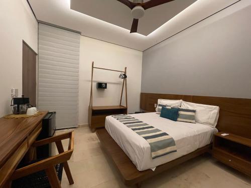 une chambre avec un grand lit et une table dans l'établissement OVA Apartments Tulum, à Tulum