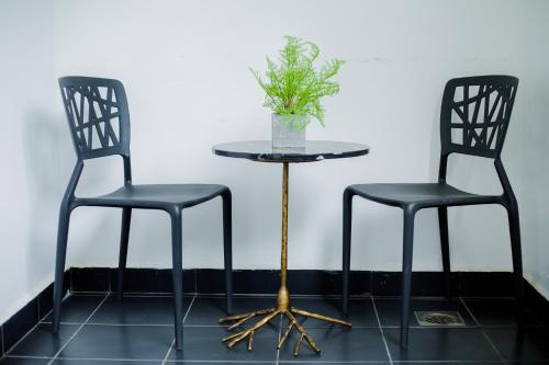 two black chairs and a table with a plant on it at Accra Luxury Apartments at Embassy Gardens in Accra