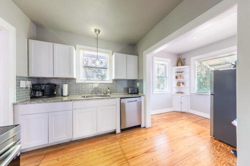 a kitchen with white cabinets and a wooden floor at Luxurious 6 bedroom villa near downtown in San Antonio