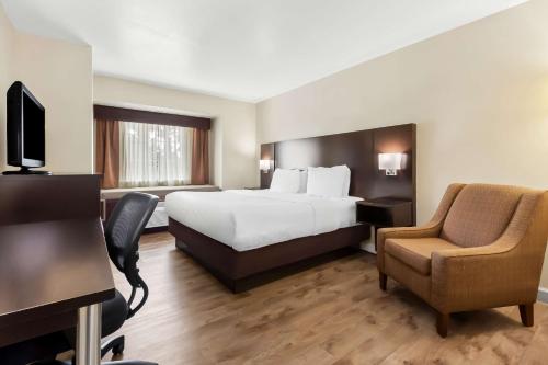 a hotel room with a bed and a chair at Best Western Patriots Point in Charleston