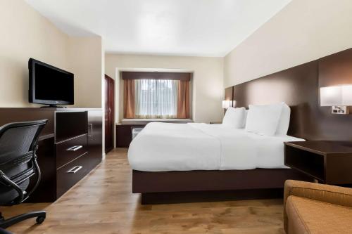 a hotel room with a large bed and a television at Best Western Patriots Point in Charleston