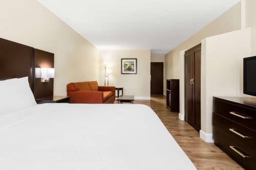 a hotel room with a bed and a chair at Best Western Patriots Point in Charleston