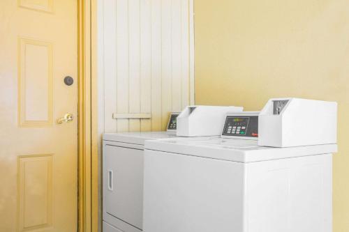 two fax machines sitting on top of a washing machine at Super 8 by Wyndham Eagle Pass in Eagle Pass