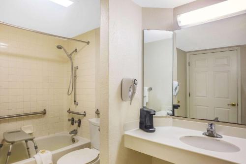 a bathroom with a sink and a toilet and a mirror at Super 8 by Wyndham Eagle Pass in Eagle Pass