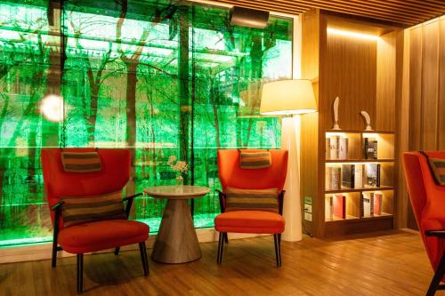 a room with three chairs and a table and a window at Park Plaza Bangkok Soi 18 in Bangkok