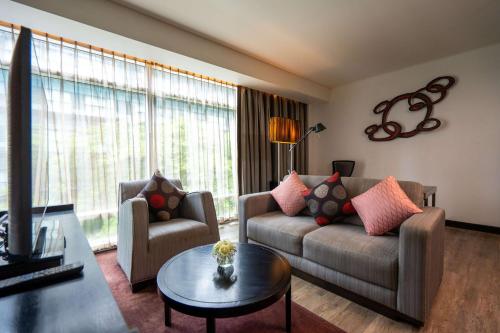 a living room with a couch and a table at Park Plaza Bangkok Soi 18 in Bangkok