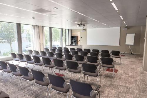 a conference room with chairs and a white screen at Radisson Blu Hotel, Lucerne in Luzern