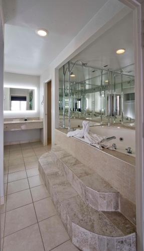 a large bathroom with a tub and a large mirror at Best Western Plus Hotel & Conference Center in Baltimore