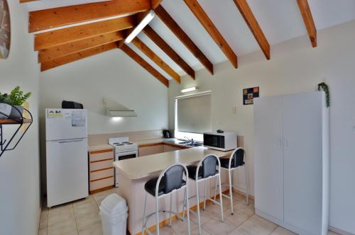 eine Küche mit einem weißen Kühlschrank sowie einem Tisch und Stühlen in der Unterkunft Lorraine's Place - Kalbarri, WA in Kalbarri