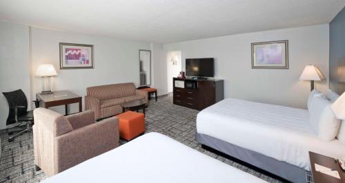 a hotel room with a bedroom with a bed and a desk at Best Western Plus Hotel & Conference Center in Baltimore