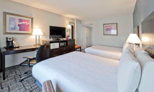 a hotel room with two beds and a desk at Best Western Plus Hotel & Conference Center in Baltimore